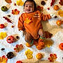 Vikranth joined the competition — help win amazing prizes! baby, infant, autumn, fall_leaves, pumpkins, pine_cones, blanket, orange_clothing, smiling, cozy, festive, seasonal, cute, lying_down, handwear, socks, decorations, harvest, nature, celebration
