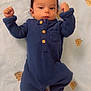 baby, infant, onesie, blue_clothing, raised_fists, blanket, teddy_bear_pattern, cute, indoor, lying_down, child, portrait, small_feet, face, buttoned_onesie, soft_texture, sleepwear, adorable, young_child, cozy