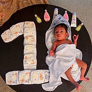 Vikranth joined the competition — help win amazing prizes! baby, infant, towel, diapers, baby_lotion, table, carpet, hand, cloth, milestone, number_one, wrapped, skin, cute, newborn, celebration, indoor, floor, person, small
