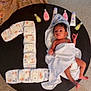 baby, infant, towel, diapers, baby_lotion, table, carpet, hand, cloth, milestone, number_one, wrapped, skin, cute, newborn, celebration, indoor, floor, person, small