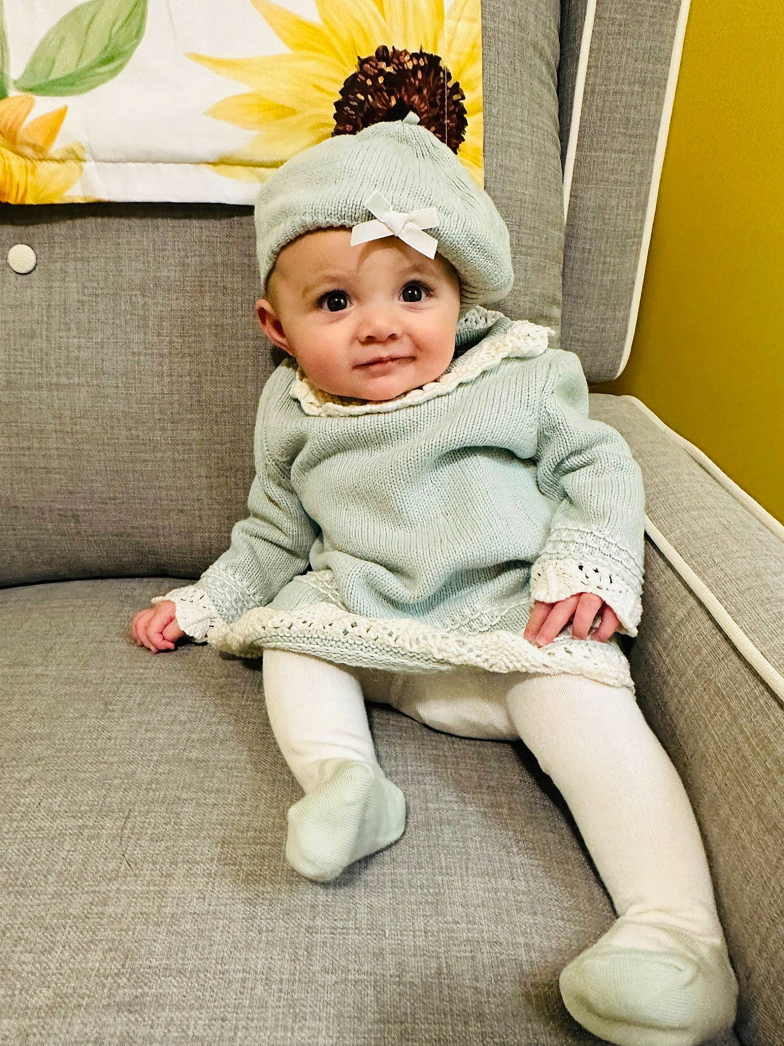 Taylor is registered to the contest to win money with this photo: baby, baby_toddler_clothing, beanie, cap, child, comfort, couch, fashion_accessory, flooring, foot, fur, grass, happy, headband, headgear, headwear, human_leg, person, sitting, sleeve