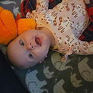 Eleanor joined the competition — help win amazing prizes! baby, blanket, cat_pattern, child, cozy, cute, elephant_pattern, eyes, fabric, face, head, indoor, infant, lying_down, mouth_open, onesie, orange, patterned, plush_toy, soft_toy