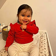 Alma participe au concours pour gagner de l'argent avec cette photo : child, toddler, baby, smiling, red_shirt, white_pants, changing_table, nursery, indoor, portrait, happy, cute, sitting, face, eyes, dark_hair, towel, basket, baby_products, skin