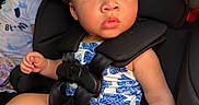 Samiyah is registered to the contest to win money with this photo: baby, child, infant, car_seat, seatbelt,  안전, portrait, wide_eyed, curly_hair, sitting, vehicle, backseat, travel, floral_clothing, toy, red_buckle, second_child, indoors, close_up, family