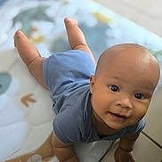 Lennox is registered to the contest to win money with this photo: baby, child, infant, crawling, blue_clothing, onesie, play_mat, smiling, happy, indoors, cute, face, skin, head, hands, floor, young, portrait, person, childhood