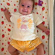 Alba a rejoint le concours — aidez-le/la à gagner de superbes lots ! baby, infant, smiling, child, cute, blanket, strawberry_pattern, tshirt, shorts, pacifier, toy, lying_down, happy, indoors, person, face, skin, head, arm, leg