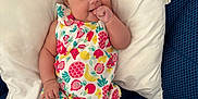 Alba participe au concours pour gagner de l'argent avec cette photo : baby, infant, child, couch, pillow, romper, colorful_clothing, fruit_pattern, hand, thumb_sucking, hair, face, legs, barefoot, indoors, seated, expression, cute, comfortable, blue_couch