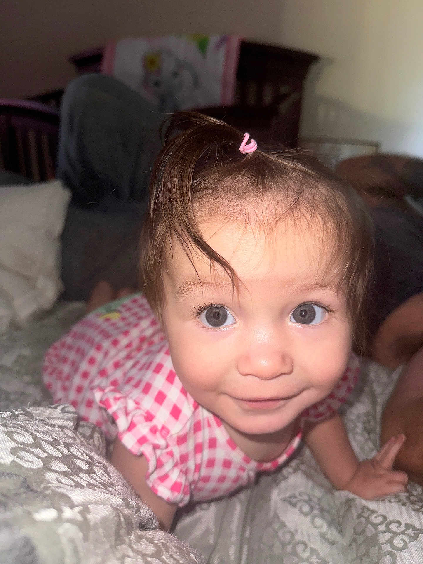 Lilliana joined the competition — help win amazing prizes! toddler, child, baby, crawling, pink_dress, hair_tie, bedroom, blanket, bed, person, face, eyes, smile, curious, indoors, closeup, furniture, soft_lighting, cute, young_child