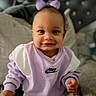 Annalise joined the competition — help win amazing prizes! toddler, child, baby, smile, purple_bow, nike_sweatshirt, clothing, indoor, bed, pillow, headboard, person, cute, portrait, young_child, sitting, happy, fashion, cozy, soft_lighting
