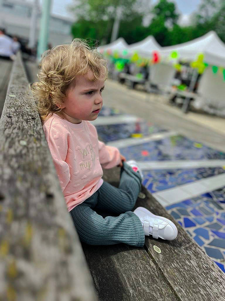 Elisa a rejoint le concours — aidez-le/la à gagner de superbes lots ! child, city, daytime, flooring, fun, grass, happy, leisure, people, person, play, recreation, roof, sitting, street, t_shirt, tent, toddler, tree, vacation