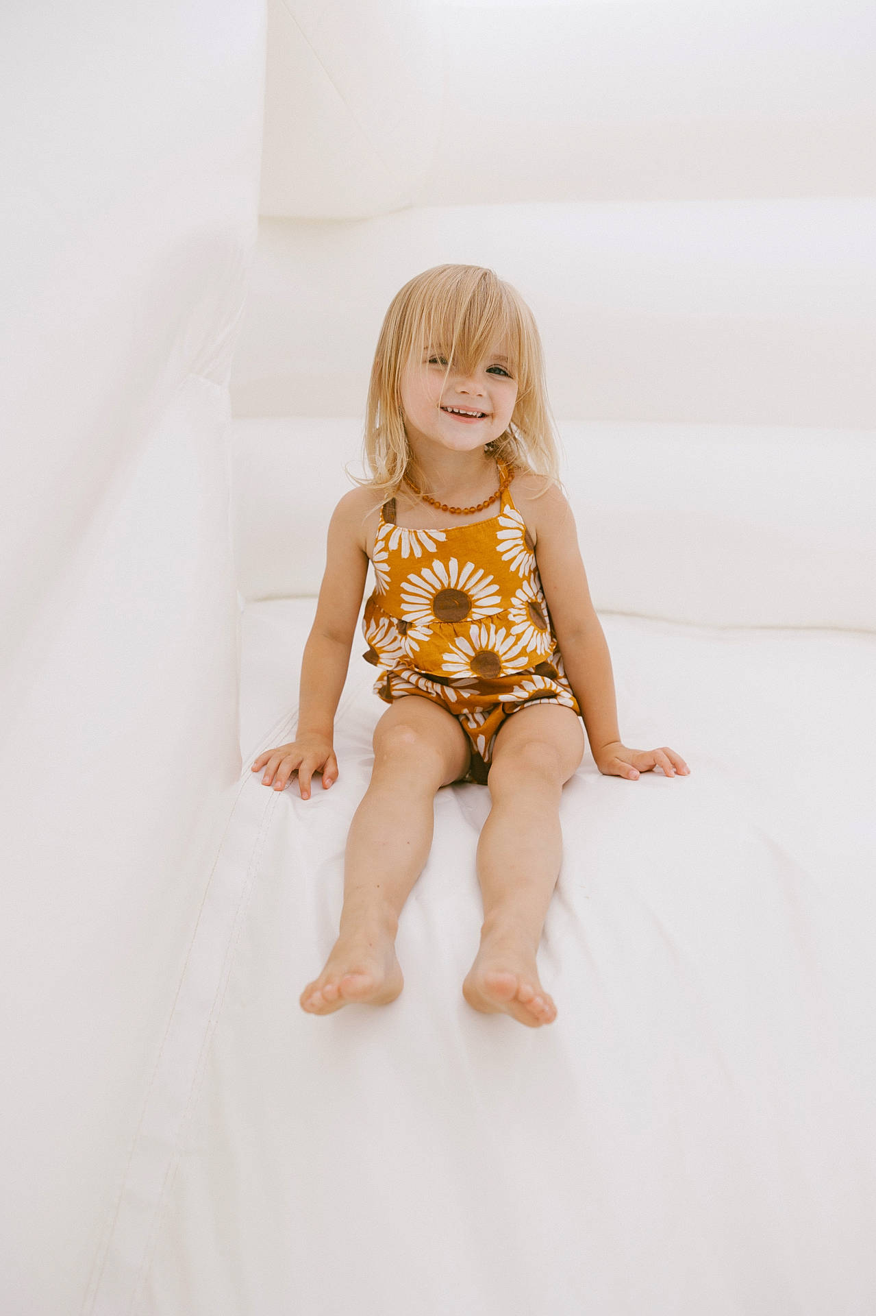 Ila is registered to the contest to win money with this photo: accessories, blonde, bodypart, child, clothing, dress, face, female, finger, girl, hair, hand, happy, head, person, photography, portrait, sitting, smile, toy