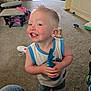Kaiser joined the competition — help win amazing prizes! child, toddler, smiling, indoor, carpet, toy, barefoot, shirt, shorts, living_room, furniture, casual, happy, playful, person, blonde_hair, home, feet, cheerful, clothing