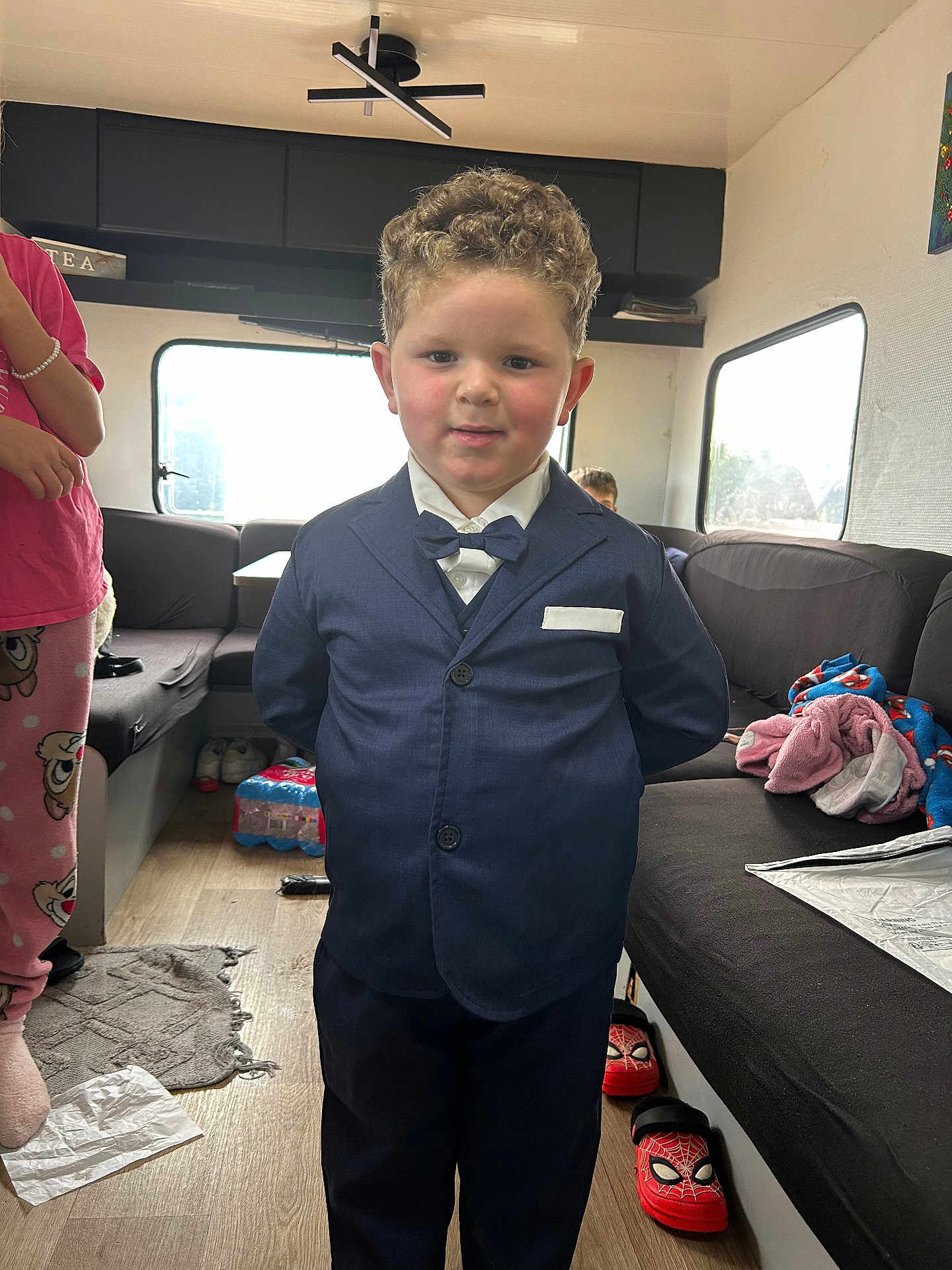 Nill a rejoint le concours — aidez-le/la à gagner de superbes lots ! child, boy, suit, bow_tie, indoor, living_room, couch, curly_hair, smile, carpet, window, slippers, blanket, floor, person, casual, clothing, furniture, child_in_pajamas, home