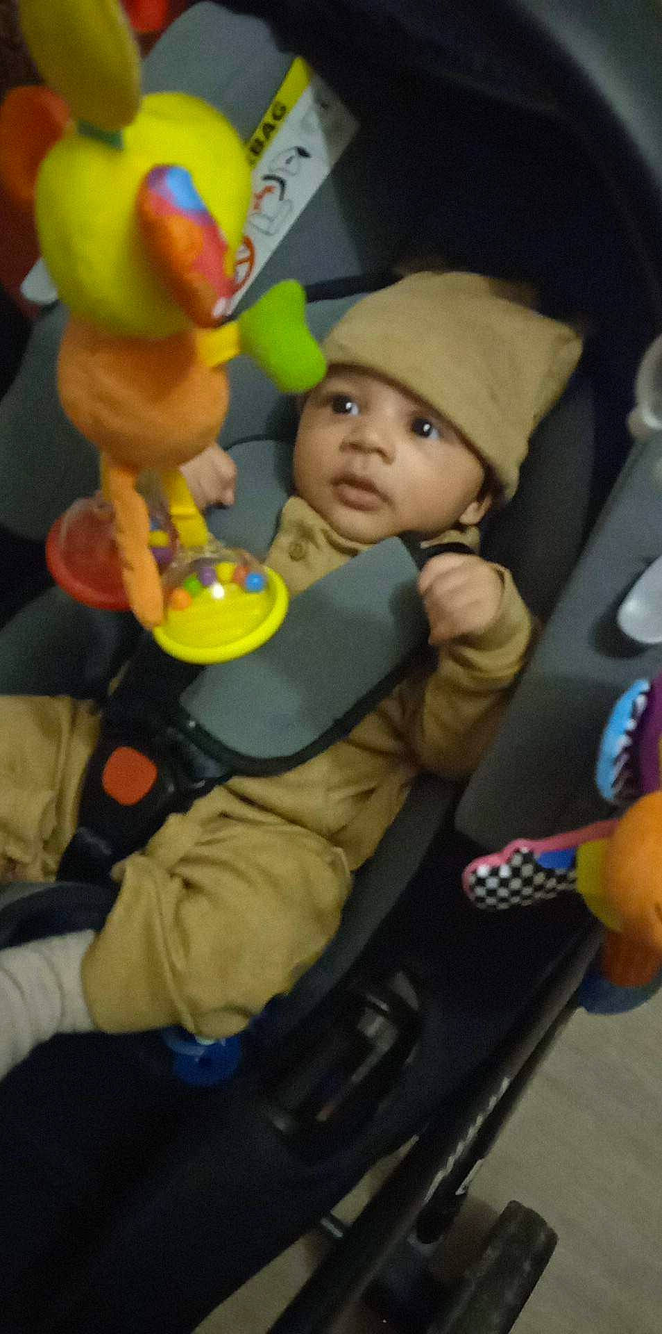 Mohamed participe au concours pour gagner de l'argent avec cette photo : baby, baby_products, baby_safety, baby_toys, car_seat, child, event, fun, headwear, leisure, person, play, room, sitting, snapshot, stuffed_toy, toddler, toy, vehicle_door, yellow