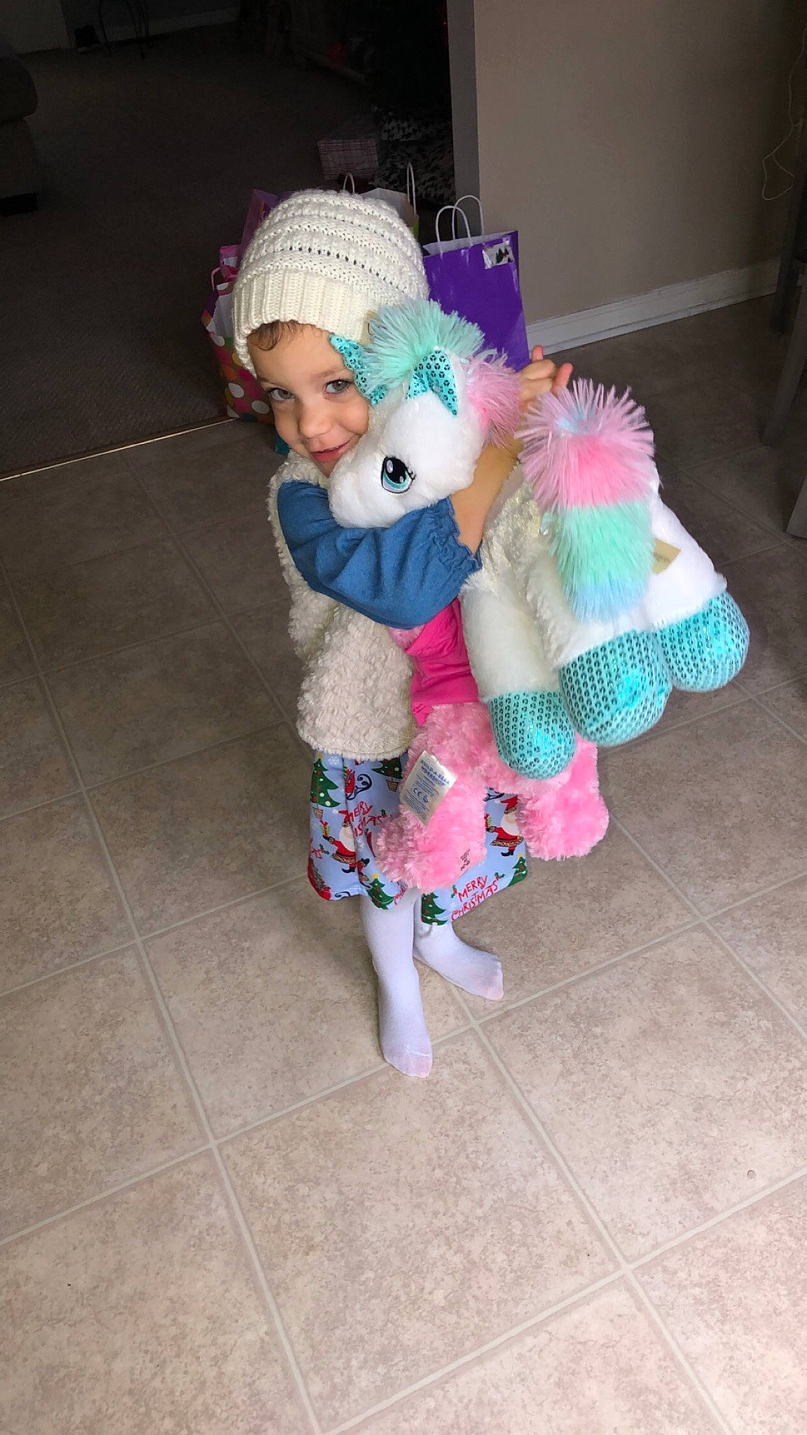 Jayda is registered to the contest to win money with this photo: baby, baby_toddler_clothing, beanie, cap, child, fashion_accessory, flooring, foot, fun, fur, headgear, headwear, knit_cap, magenta, pattern, person, pink, sleeve, stuffed_toy, toddler