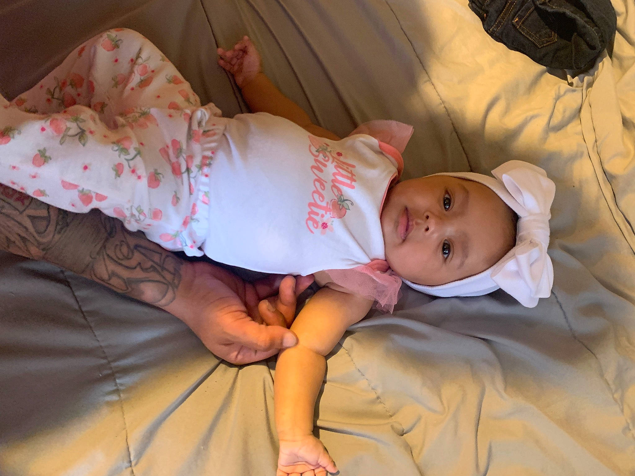Kaliyah is registered to the contest to win money with this photo: baby, baby_toddler_clothing, child, comfort, event, eye, foot, happy, hat, head, human_leg, linens, pattern, person, room, sitting, skin, sleeve, smile, textile