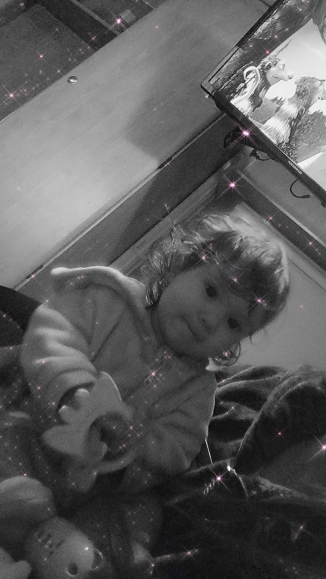 Sophie participe au concours pour gagner de l'argent avec cette photo : animation, black_and_white, blanket, casual, child, couch, cozy, cute, face, furniture, hair, hoodie, indoor, portrait, room, sitting, sparkle_filter, television, toddler, toy