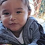 Lisandro Mendez joined the competition — help win amazing prizes! toddler, child, face, portrait, outdoor, jacket, gray_clothing, curly_hair, fence, daylight, person, young_child, casual_clothing, expression, close_up, hand, nature, smile, eye_contact, cute