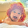baby, smiling, happy, infant, child, lying_down, orange_wig, yarn_hat, cute, indoors, soft_light, window, white_bedding, playful, portrait, skin, face, expression, toddler, cozy