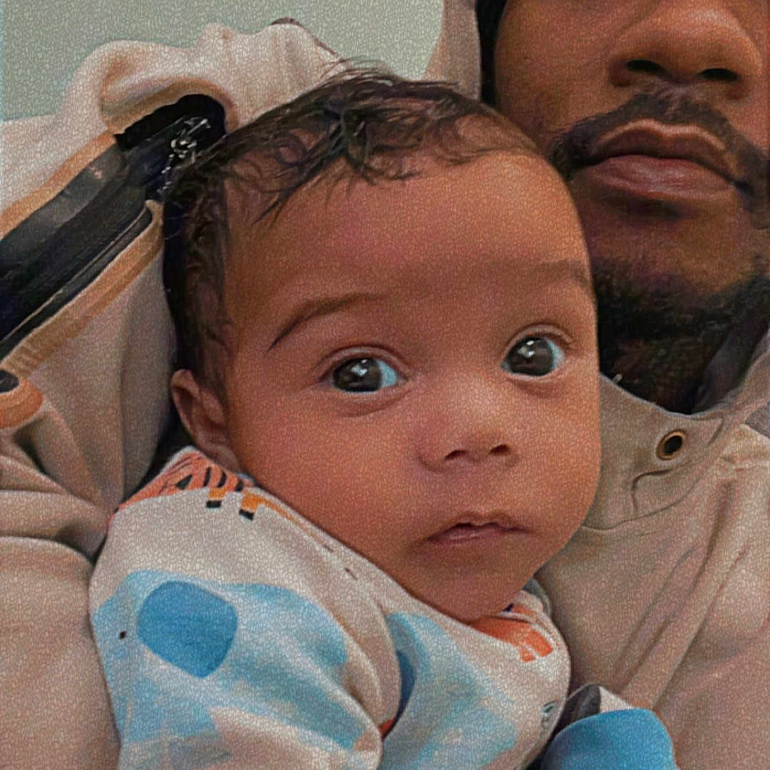 Kyaire is registered to the contest to win money with this photo: baby, man, portrait, indoor, clothing, hoodie, child, person, face, expression, holding, pajamas, colorful, nostalgia, timestamp, vhs_effect, closeup, cute, warm, family