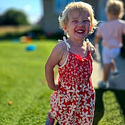 Jadelyn is registered to the contest to win money with this photo: background, backyard, blonde_hair, child, family, floral_dress, girl, grass, happy, house, outdoor, playground, portrait, red_clothing, running, smiling, standing, summer, sunlight, toddler