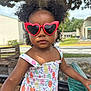 Maliyah joined the competition — help win amazing prizes! bench, child, colorful, curly_hair, dress, fruit_pattern, heart_shaped, nature, outdoor, person, play, playground, portrait, red, summer, sunglasses, sunny, toddler, tree, young_child