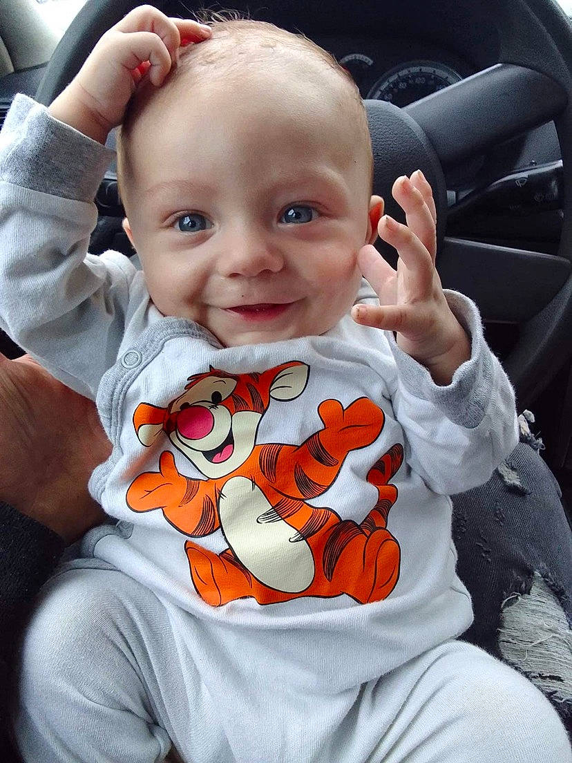 Thyago a rejoint le concours — aidez-le/la à gagner de superbes lots ! baby, baby_products, baby_toddler_clothing, cheek, child, cool, finger, gesture, happy, human_body, joy, orange, person, plant, sitting, sleeve, smile, steering_wheel, t_shirt, thumb