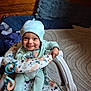 baby, child, smiling, hat, baby_walker, indoor, wooden_wall, cushion, playful, happy, clothing, toy, seat, person, infant, cute, floor, fabric, comfortable, portrait