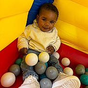 Baby Bear joined the competition — help win amazing prizes! ball_pit, balls, blue, casual_clothing, child, colorful, cute, fun, gray_balls, happy, indoor, play, portrait, red, smiling, sneakers, teal_balls, toddler, white_balls, yellow