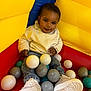 ball_pit, balls, blue, casual_clothing, child, colorful, cute, fun, gray_balls, happy, indoor, play, portrait, red, smiling, sneakers, teal_balls, toddler, white_balls, yellow