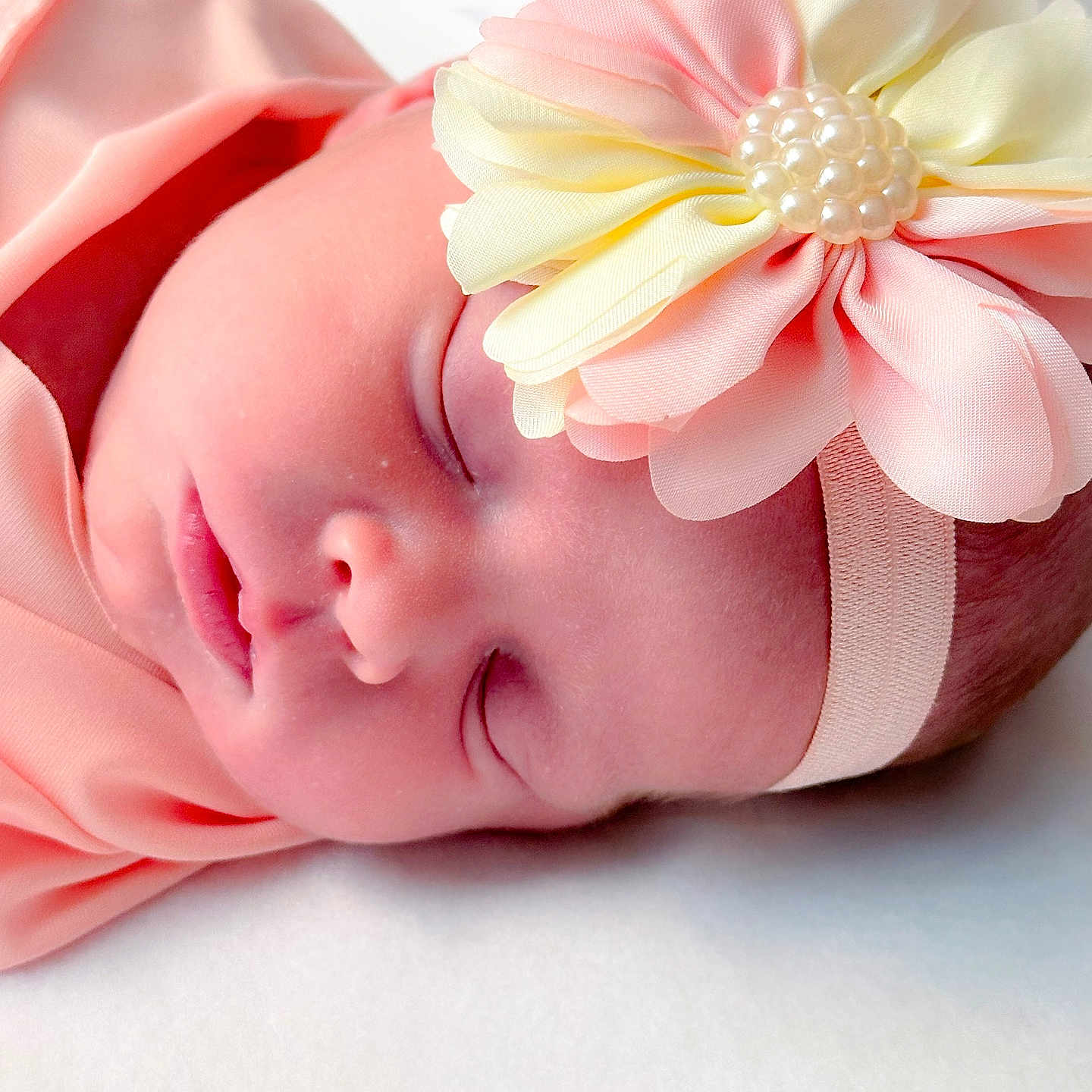 Enid is registered to the contest to win money with this photo: newborn, baby, sleeping, headband, flower, pink_clothing, closeup, infant, peaceful, soft, cute, portrait, skin, face, child, resting, adorable, indoors, baby_girl, sleep
