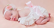 Enid joined the competition — help win amazing prizes! baby, newborn, infant, headband, flower, pink_bow, lace_clothing, soft_background, sleepy, cute, peaceful, portrait, lying_down, skin, closeup, child, adorable, baby_girl, soft_texture, delicate