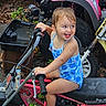 Taylor joined the competition — help win amazing prizes! child, toddler, girl, smiling, tongue_out, portrait, outdoor, off_road_vehicle, buggy, atv, pink_vehicle, blue_swimsuit, sitting, playful, happy, vehicle, tires, handlebars, leaves, backyard