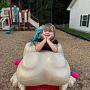 Cadence joined the competition — help win amazing prizes! child, girl, toddler, playground, playground_equipment, frog_ride, outdoor, smiling, happy, portrait, sitting, hands_on_cheeks, blonde_hair, long_hair, black_shirt, mulch, forest, house, slide, recreation