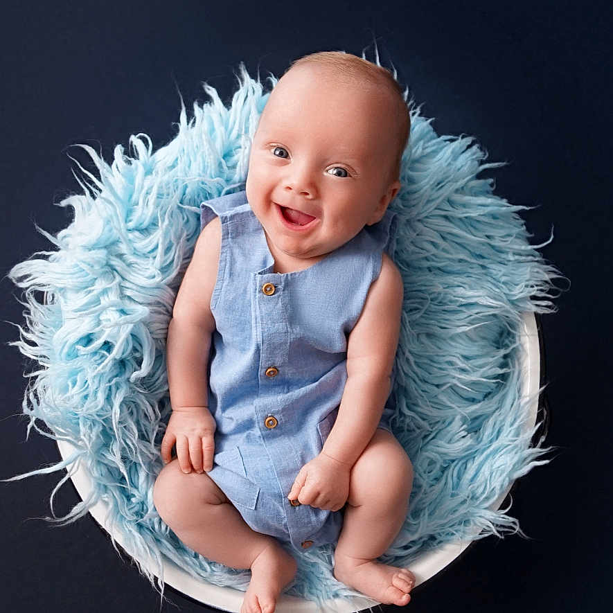 Logan joined the competition — help win amazing prizes! baby, bodypart, bonnet, clothing, face, finger, furniture, hand, happy, hat, head, newborn, pants, person, photography, portrait, sitting, sleeping, smile, toy
