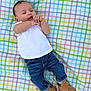 baby, infant, child, plaid_blanket, white_shirt, blue_jeans, brown_shoes, lying_down, cute, hands, face, relaxed, outdoor, pattern, colorful, clothing, portrait, small_child, footwear, casual