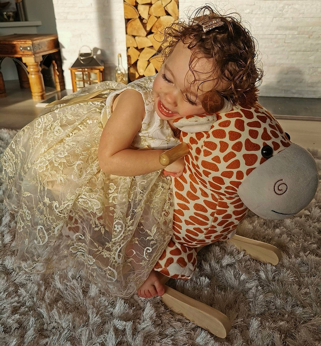 Kora is registered to the contest to win money with this photo: baby, chair, child, comfort, dress, event, fashion_design, floor, flooring, fun, furniture, hair, happy, linens, pattern, person, room, sitting, tablecloth, textile