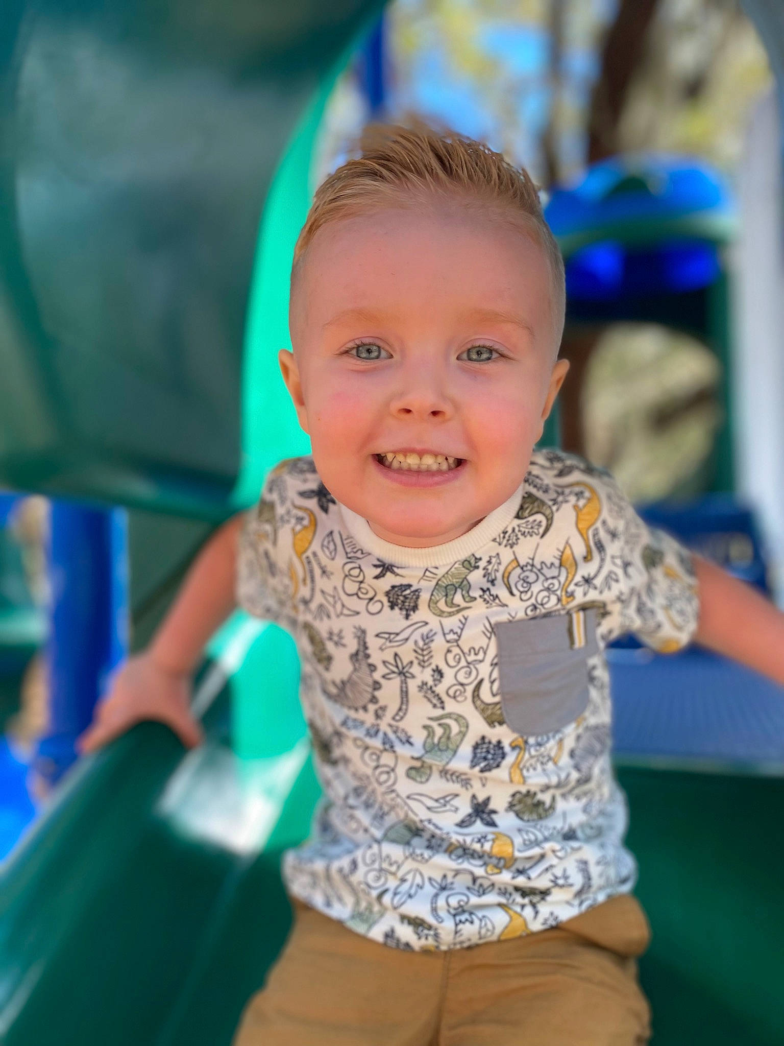 Brenden is registered to the contest to win money with this photo: child, city, electric_blue, event, facial_expression, fun, grass, happy, iris, joy, laugh, leisure, outdoor_play_equipment, person, play, playground, recreation, sitting, smile, t_shirt