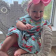 Henrietta-Rain joined the competition — help win amazing prizes! baby, child, girl, smile, pink_bow, floral_dress, wicker_chair, indoor, window, lake_view, nature, wooden_floor, happy, cute, portrait, seated, foot, hand, headband, daylight