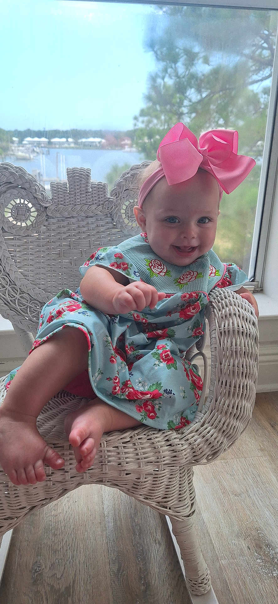 Henrietta-Rain joined the competition — help win amazing prizes! baby, child, girl, smile, pink_bow, floral_dress, wicker_chair, indoor, window, lake_view, nature, wooden_floor, happy, cute, portrait, seated, foot, hand, headband, daylight