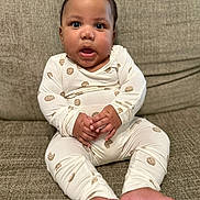 Jonah is registered to the contest to win money with this photo: baby, child, infant, sitting, couch, indoors, portrait, close_up, face, wide_eyed, open_mouth, hands, feet, pajamas, cookie_pattern, clothing, cushion, furniture, cute, photography