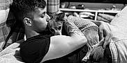 Monty joined the competition — help win amazing prizes! man, dog, cuddle, tattoo, blanket, sweater, black_and_white, indoor, relaxation, comfort, pet, friendship, love, casual_clothing, home, portrait, resting, close_up, face, arm