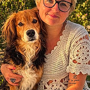Sandy a rejoint le concours — aidez-le/la à gagner de superbes lots ! woman, dog, pet, outdoor, portrait, glasses, smiling, short_hair, tattoo, crochet_top, casual, affection, nature, sunlight, greenery, seated, friendship, animal, happy, companionship
