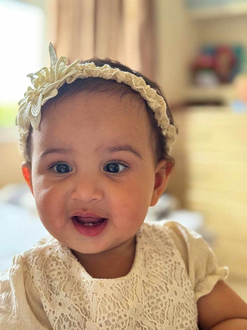Meera joined the competition — help win amazing prizes! baby, child, face, smile, headband, flower, lace, dress, indoor, portrait, cute, infant, young_child, happy, skin, eyes, mouth, person, apparel, headwear