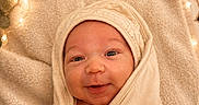Jaylen is registered to the contest to win money with this photo: baby, smile, blanket, wrapped, cozy, face, infant, newborn, soft, warm, fairy_lights, eucalyptus, closeup, portrait, cute, happy, skin, indoors, comfort, peaceful