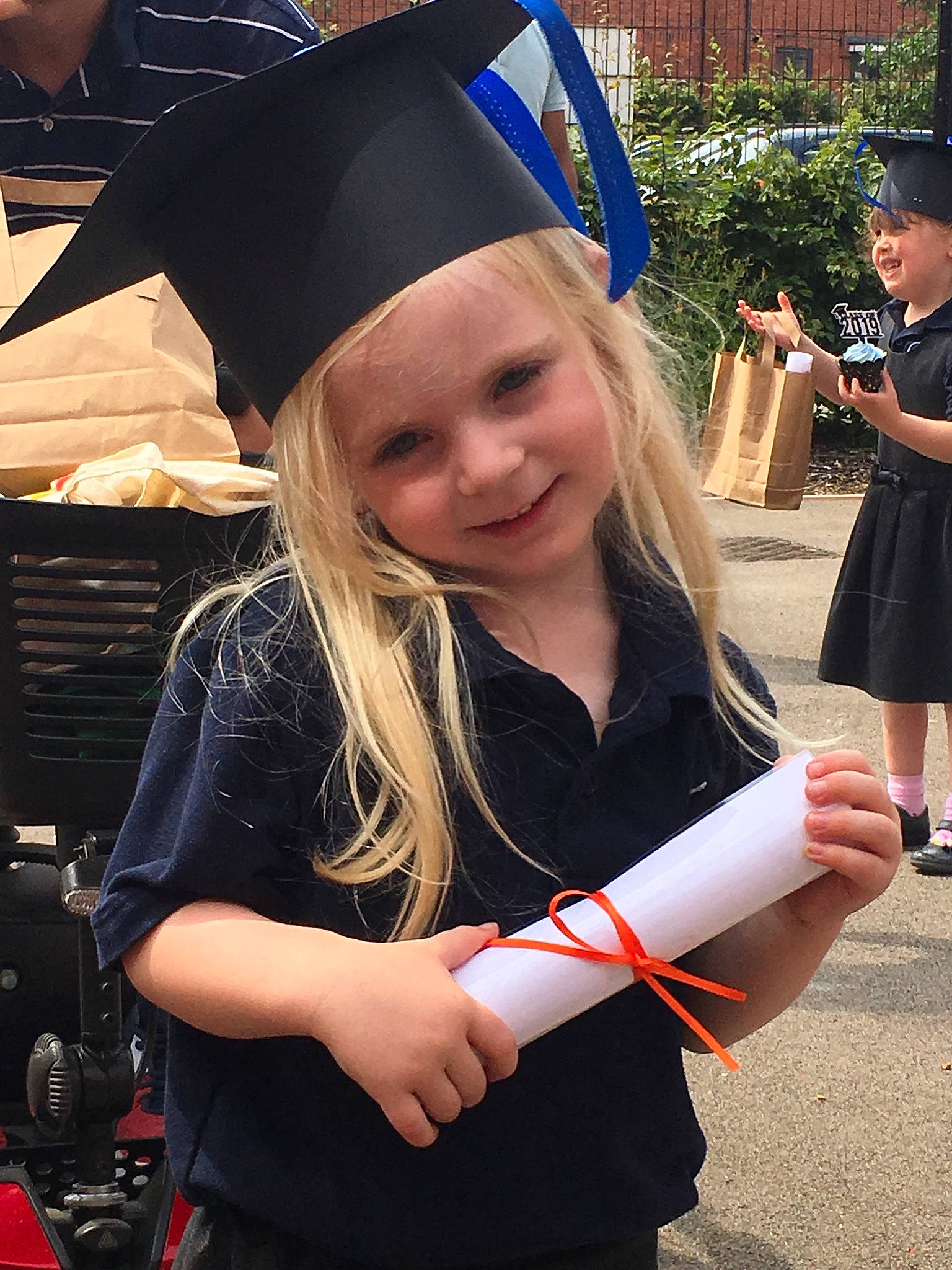 Louise is registered to the contest to win money with this photo: academic_dress, academic_institution, clothing, college, diploma, event, fun, graduation, headgear, headwear, joy, long_hair, luxury_vehicle, mortarboard, person, phd, photography, public_event, scholar, smile