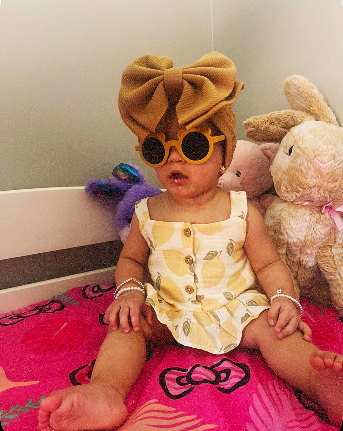 Thianelys Enaï joined the competition — help win amazing prizes! baby, baby_toddler_clothing, child, doll, eyewear, fun, goggles, happy, hat, headgear, magenta, person, pink, plush, sitting, skin, stuffed_toy, sunglasses, textile, toddler
