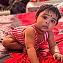 Harini joined the competition — help win amazing prizes! baby, child, crawling, bed, striped_clothing, red, black_dot, face, arm, hand, indoors, curious, skin, short_hair, earrings, blanket, pattern, furniture, person, portrait