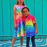 child, children, smiling, standing, colorful_clothing, rainbow, dress, shirt, boots, spiderman, sneakers, happy, outdoor, wall, turquoise, pattern, friendship, playful, portrait, kids