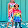 child, children, colorful_clothing, rainbow, dress, shirt, boots, sneakers, spiderman, pattern, standing, outdoor, wall, turquoise, happy, smiling, person, kids, fashion, playful